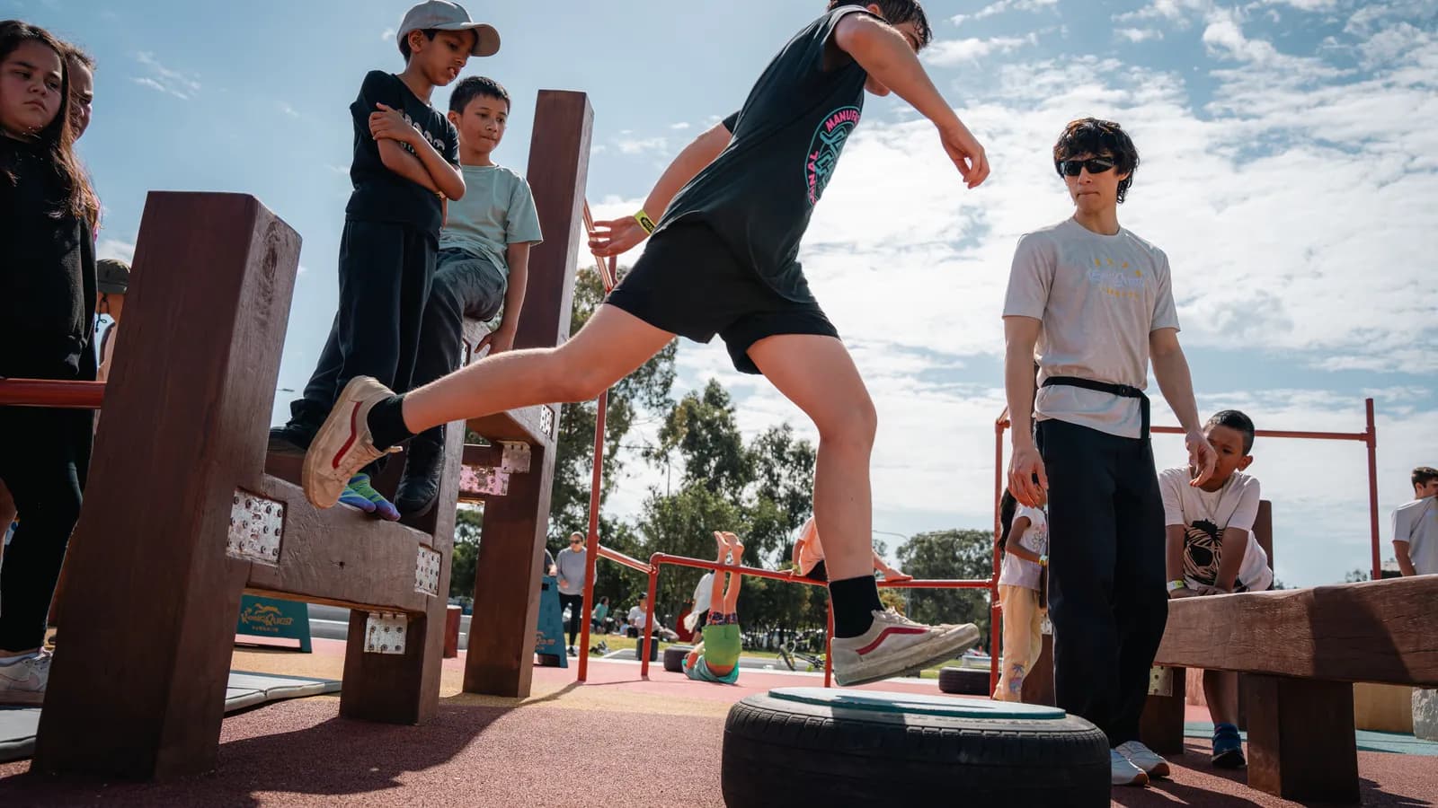 A young traceur mid-leap across the Pop-Up obstacle course