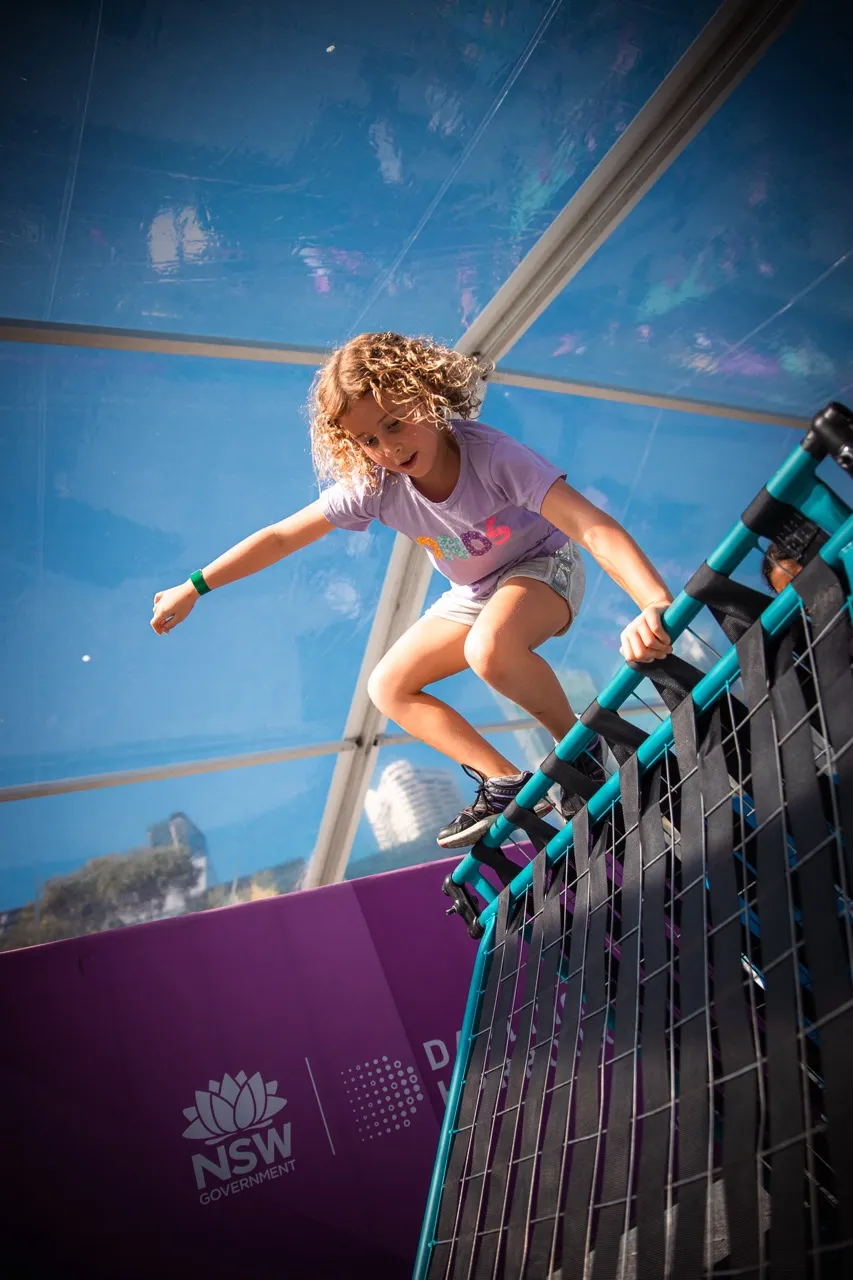 A child vaulting under the covered marquee at an NSW Government festival